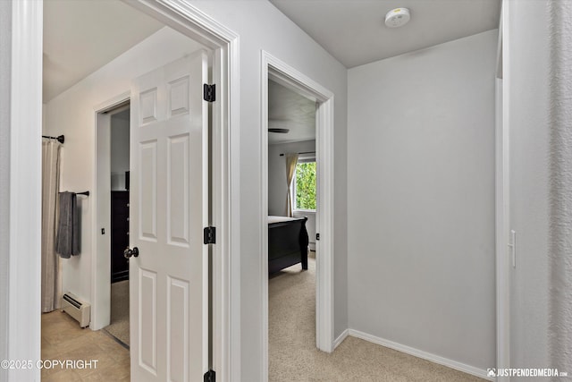 hall with a baseboard radiator and baseboards