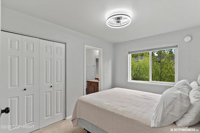 bedroom featuring light carpet, a closet, baseboards, and connected bathroom