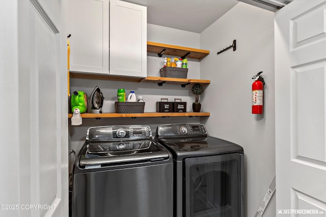 washroom with cabinet space and washing machine and dryer