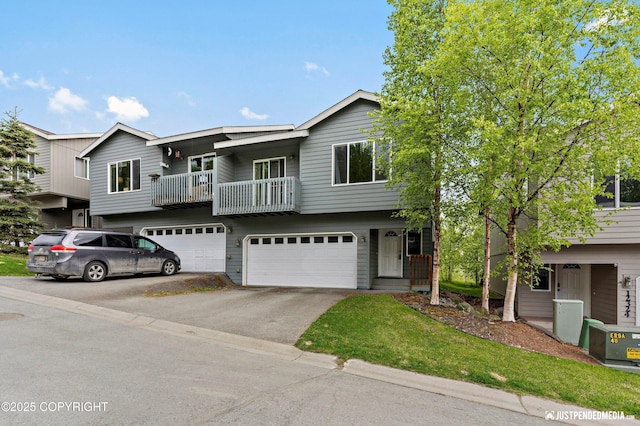 view of front of house featuring asphalt driveway, a garage, and a balcony