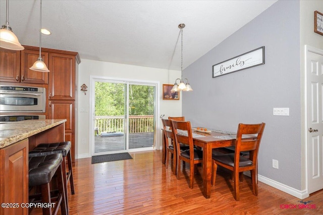 2750 E Whispering Woods Dr, Wasilla, AK 99654 - dining space with light wood-style floors, a chandelier, baseboards, and lofted ceiling