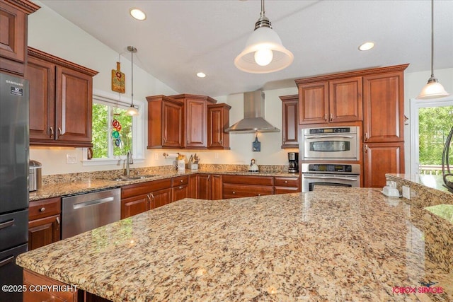 2750 E Whispering Woods Dr, Wasilla, AK 99654 - kitchen with appliances with stainless steel finishes, wall chimney exhaust hood, a sink, light stone counters, and decorative light fixtures