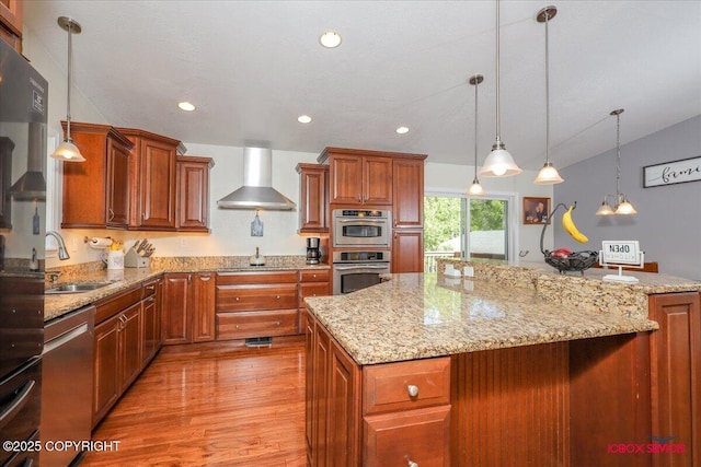 2750 E Whispering Woods Dr, Wasilla, AK 99654 - kitchen with wall chimney exhaust hood, a sink, light wood-style floors, light stone countertops, and brown cabinets