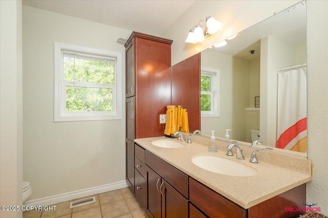 2750 E Whispering Woods Dr, Wasilla, AK 99654 - full bath featuring toilet, double vanity, baseboards, and tile patterned floors