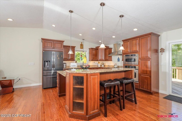 2750 E Whispering Woods Dr, Wasilla, AK 99654 - kitchen featuring appliances with stainless steel finishes, wall chimney exhaust hood, light wood-style floors, a center island, and recessed lighting