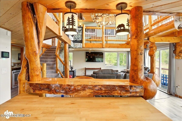 living area featuring wood finished floors, wood ceiling, and stairway