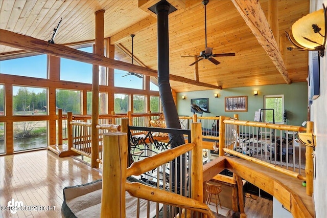 hallway featuring wood ceiling, beam ceiling, hardwood / wood-style flooring, high vaulted ceiling, and a water view