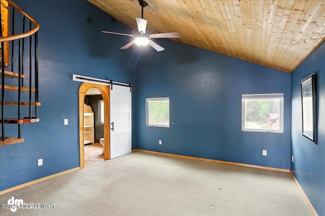 unfurnished room featuring lofted ceiling, carpet floors, ceiling fan, arched walkways, and plenty of natural light
