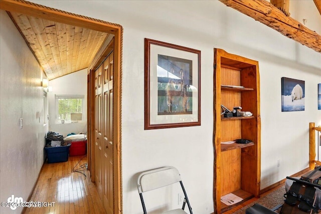 hallway featuring wood ceiling, hardwood / wood-style flooring, built in shelves, and vaulted ceiling