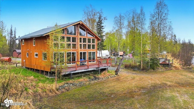 back of property featuring a wooden deck and a yard