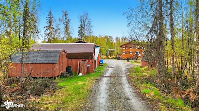 view of dirt / gravel driveway with a barn