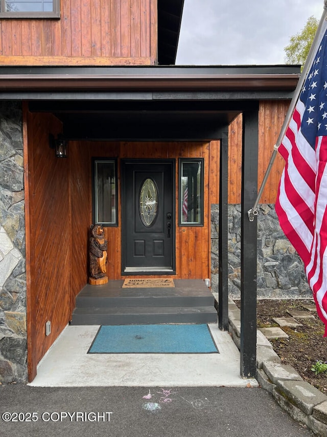 21675 Sheltering Spruce Loop, Chugiak, AK 99567 - doorway to property featuring stone siding