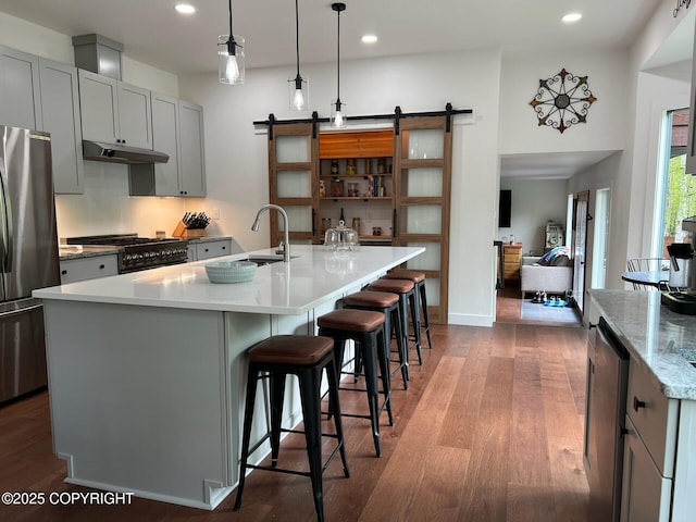 21675 Sheltering Spruce Loop, Chugiak, AK 99567 - kitchen featuring freestanding refrigerator, gray cabinetry, wood finished floors, a barn door, and recessed lighting