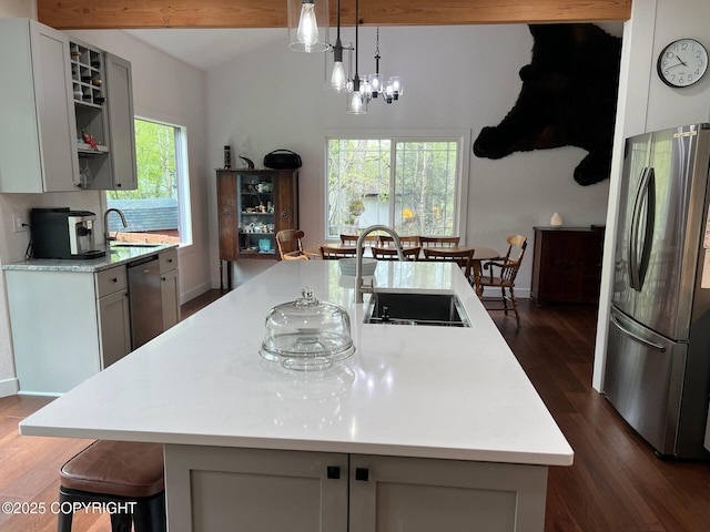 21675 Sheltering Spruce Loop, Chugiak, AK 99567 - kitchen featuring freestanding refrigerator, dishwashing machine, light countertops, dark wood-type flooring, and an island with sink