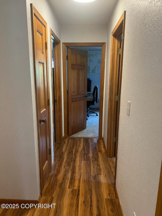 21675 Sheltering Spruce Loop, Chugiak, AK 99567 - hallway with a textured wall, wood finished floors, and a desk