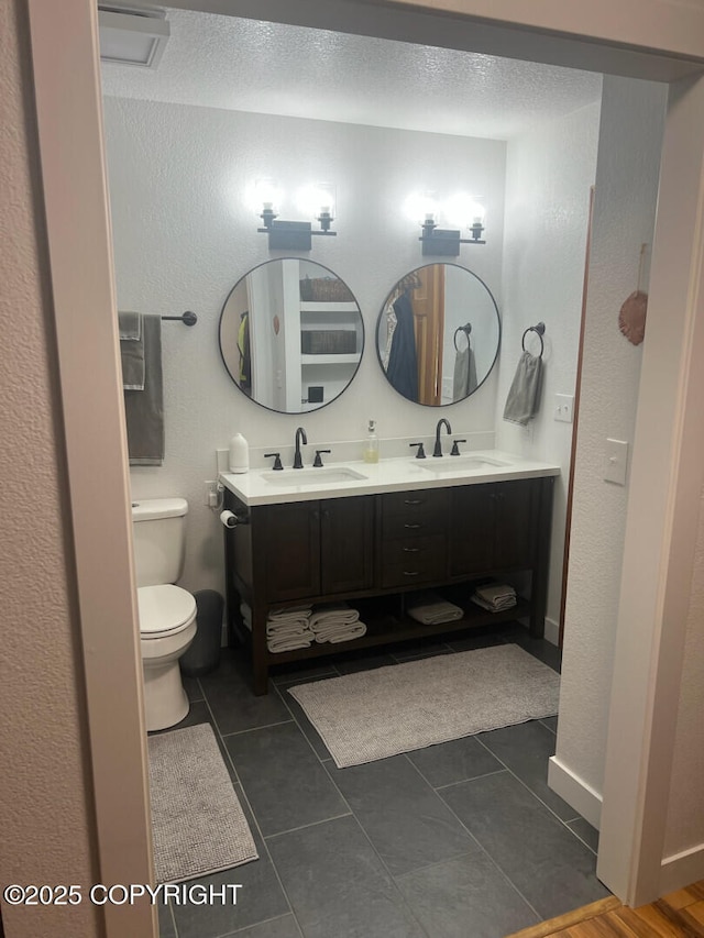 21675 Sheltering Spruce Loop, Chugiak, AK 99567 - full bath with toilet, double vanity, tile patterned floors, and a textured ceiling