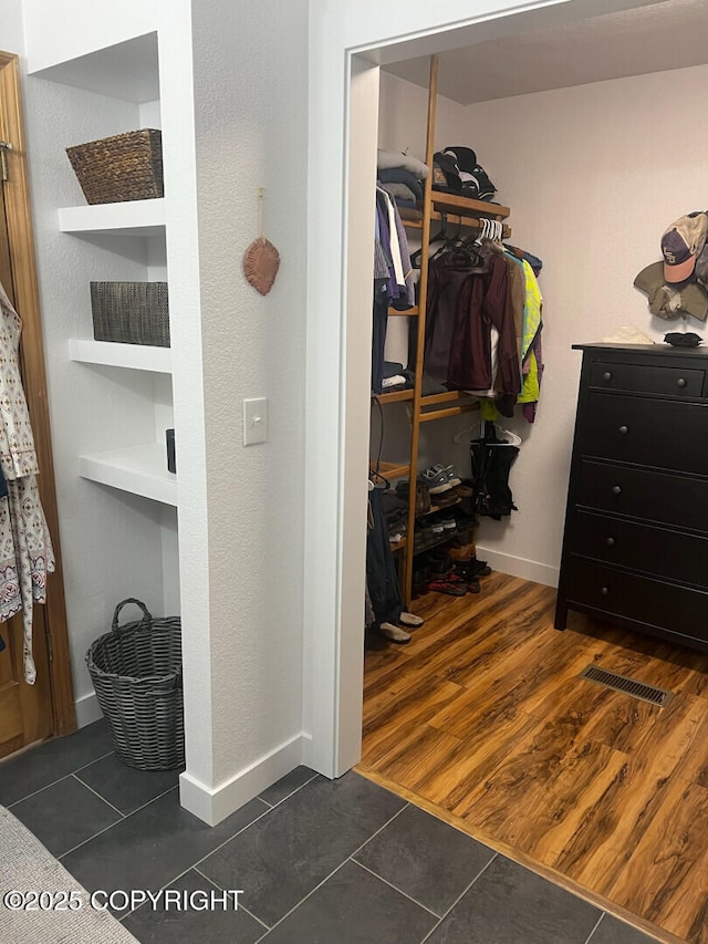 21675 Sheltering Spruce Loop, Chugiak, AK 99567 - walk in closet featuring dark tile patterned flooring