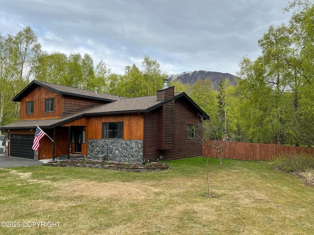 21675 Sheltering Spruce Loop, Chugiak, AK 99567 - view of front facade featuring a chimney, an attached garage, a mountain view, stone siding, and driveway