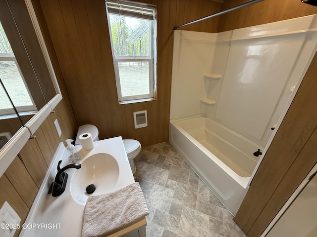 26155 W Long Lake Rd, Willow, AK 99688 - full bathroom featuring wood walls, toilet, stone finish flooring, vanity, and shower / bathtub combination