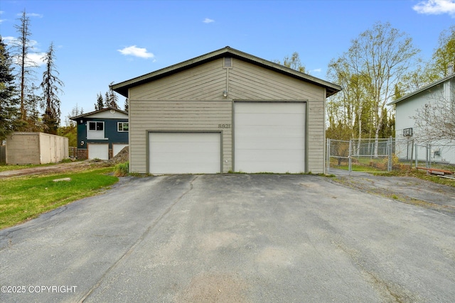 view of front facade featuring fence, an outbuilding, and a garage