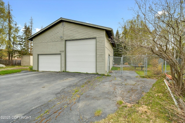 detached garage featuring a gate and fence