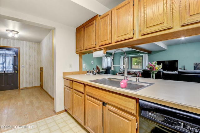 kitchen featuring dishwasher, a sink, light countertops, wallpapered walls, and baseboards