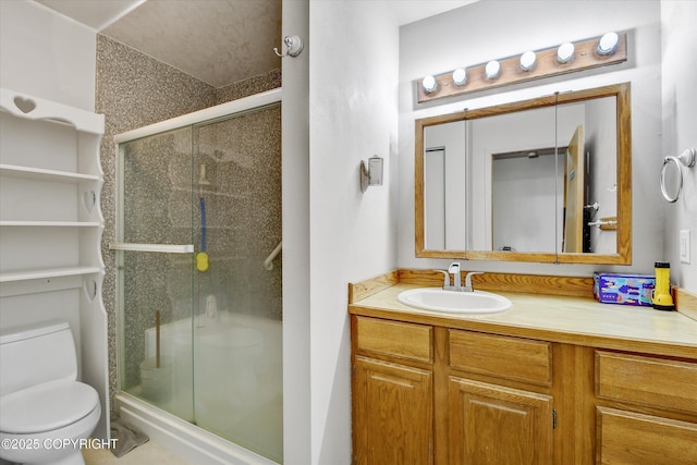 bathroom with toilet, a stall shower, and vanity