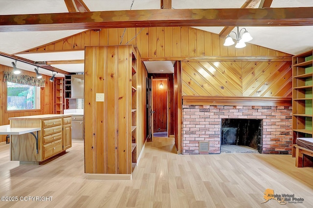 20811 Eagle River Rd, Eagle River, AK 99577 - unfurnished living room with wooden walls, light wood finished floors, a chandelier, and a fireplace