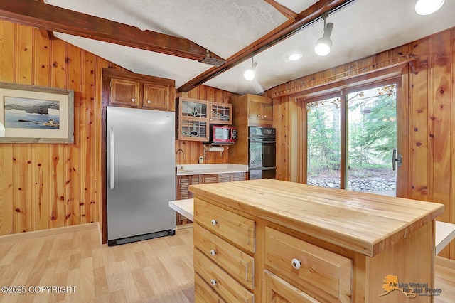 20811 Eagle River Rd, Eagle River, AK 99577 - kitchen with built in refrigerator, butcher block counters, wood walls, light wood-type flooring, and a sink