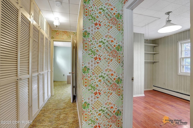 20811 Eagle River Rd, Eagle River, AK 99577 - hall featuring a baseboard radiator, wallpapered walls, a paneled ceiling, wood finished floors, and baseboards
