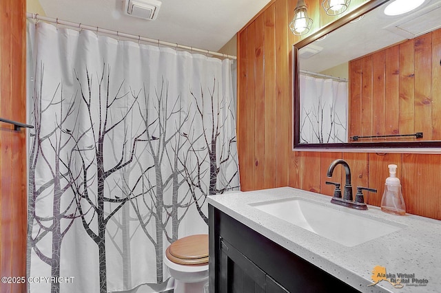 20811 Eagle River Rd, Eagle River, AK 99577 - bathroom with wood walls, vanity, and toilet