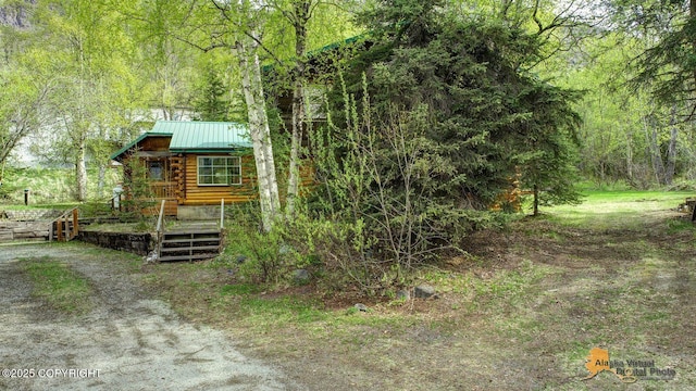 20811 Eagle River Rd, Eagle River, AK 99577 - view of front of house with log exterior, a wooded view, metal roof, and a standing seam roof