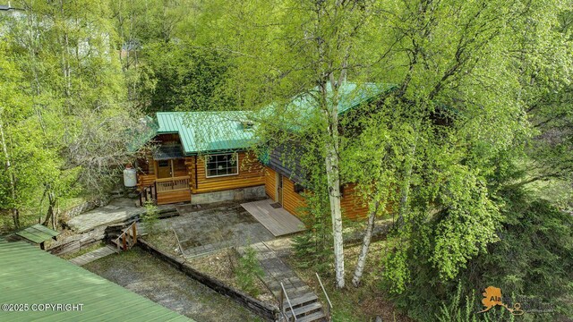 20811 Eagle River Rd, Eagle River, AK 99577 - rear view of house featuring metal roof, a wooded view, and a deck