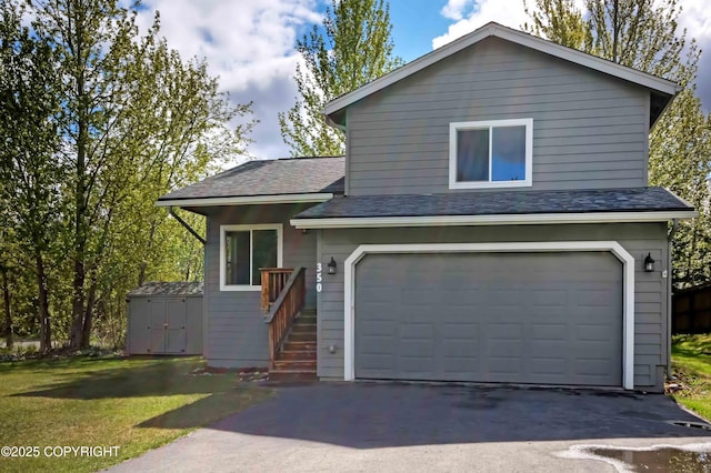 view of front facade with a garage, a storage unit, asphalt driveway, roof with shingles, and an outdoor structure