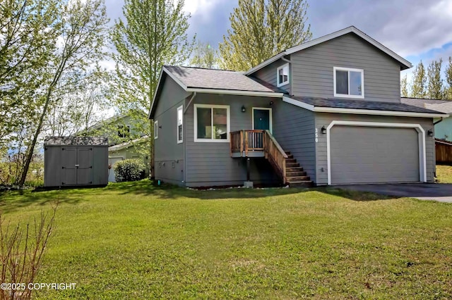 tri-level home with a storage unit, an attached garage, driveway, a front yard, and a shingled roof
