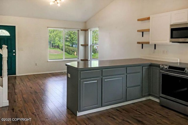 kitchen with appliances with stainless steel finishes, open shelves, lofted ceiling, gray cabinetry, and dark wood-style floors