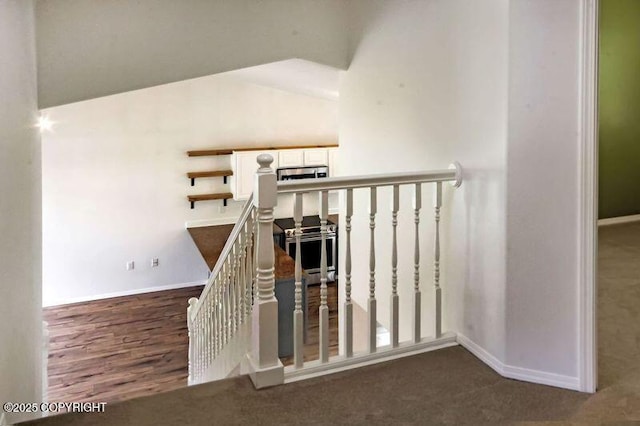 stairway with baseboards, carpet, and vaulted ceiling
