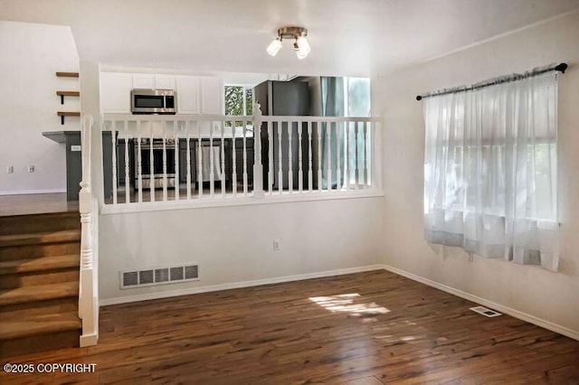 unfurnished room with wood finished floors and baseboards