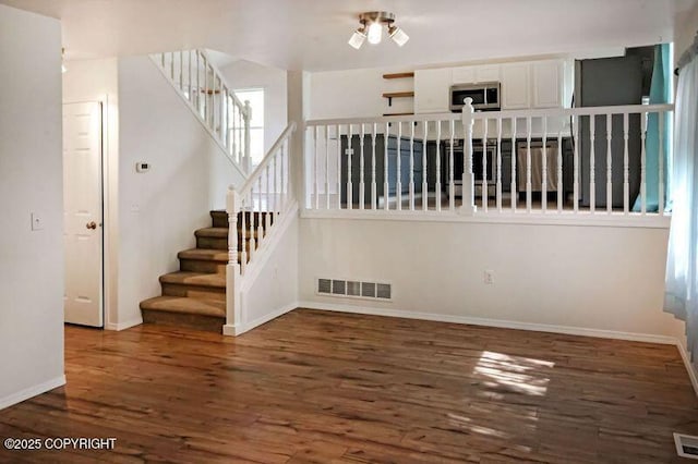 staircase with wood finished floors and baseboards