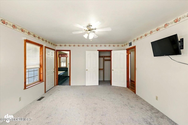 36115 Mackey Lake Rd, Soldotna, AK 99669 - unfurnished bedroom with carpet, connected bathroom, and ceiling fan
