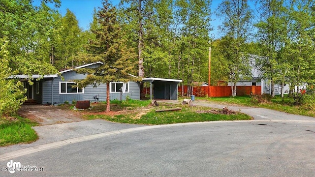 961 E Dellwood St, Wasilla, AK 99654 - view of front of home featuring driveway, a carport, and fence