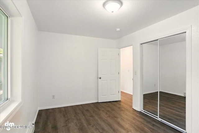 961 E Dellwood St, Wasilla, AK 99654 - unfurnished bedroom with wood finished floors, a closet, and baseboards