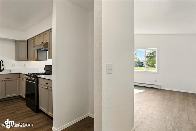 961 E Dellwood St, Wasilla, AK 99654 - kitchen featuring gas stove, a baseboard heating unit, under cabinet range hood, dark wood finished floors, and a sink
