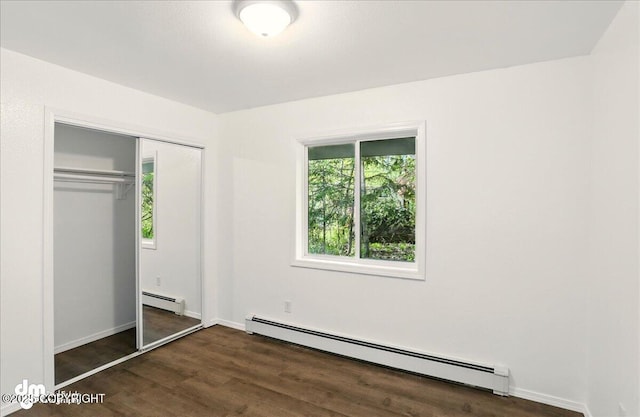 961 E Dellwood St, Wasilla, AK 99654 - unfurnished bedroom featuring baseboard heating, wood finished floors, a closet, and baseboards