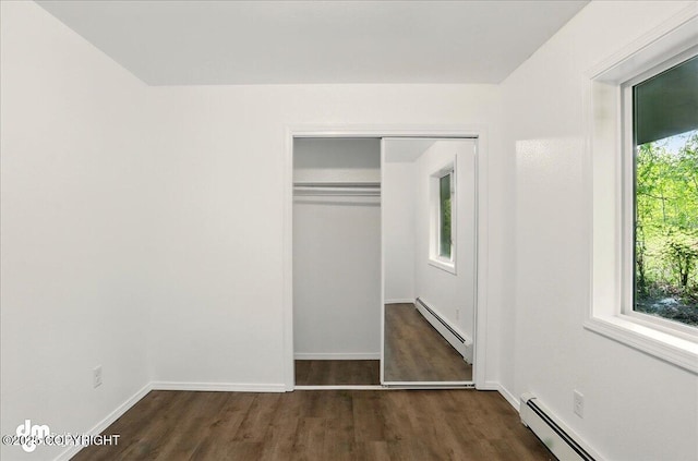 961 E Dellwood St, Wasilla, AK 99654 - unfurnished bedroom with a baseboard radiator, dark wood-style flooring, and a closet