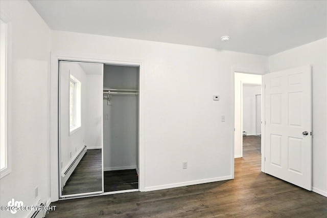 961 E Dellwood St, Wasilla, AK 99654 - unfurnished bedroom featuring a baseboard radiator, a closet, dark wood finished floors, and baseboards
