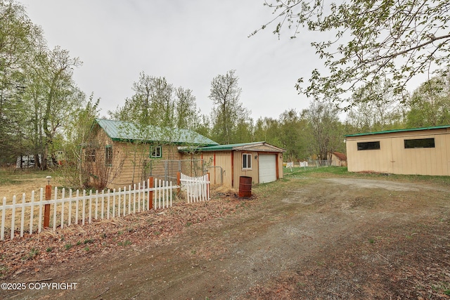 manufactured / mobile home featuring driveway, fence, and a detached garage