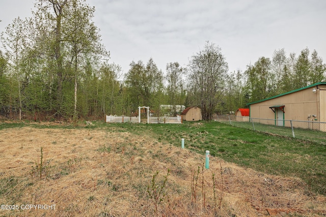 view of yard with fence, an outbuilding, and a storage shed