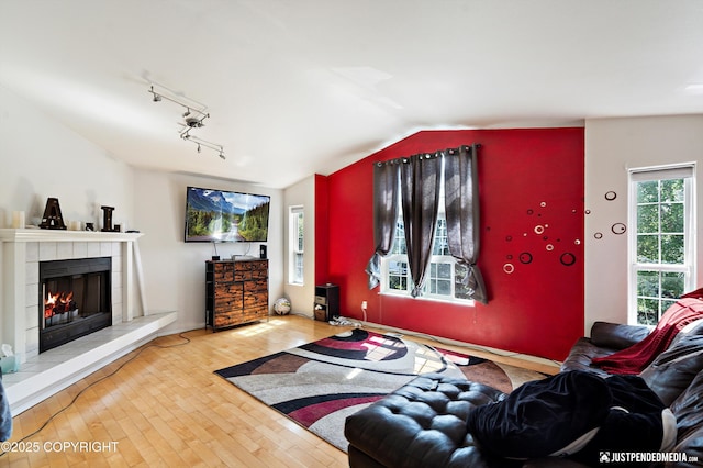 1957 Terrebonne Loop, Anchorage, AK 99502 - living area with a tile fireplace, wood finished floors, vaulted ceiling, and rail lighting