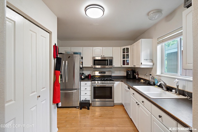 1957 Terrebonne Loop, Anchorage, AK 99502 - kitchen with appliances with stainless steel finishes, dark countertops, light wood-style floors, and white cabinets